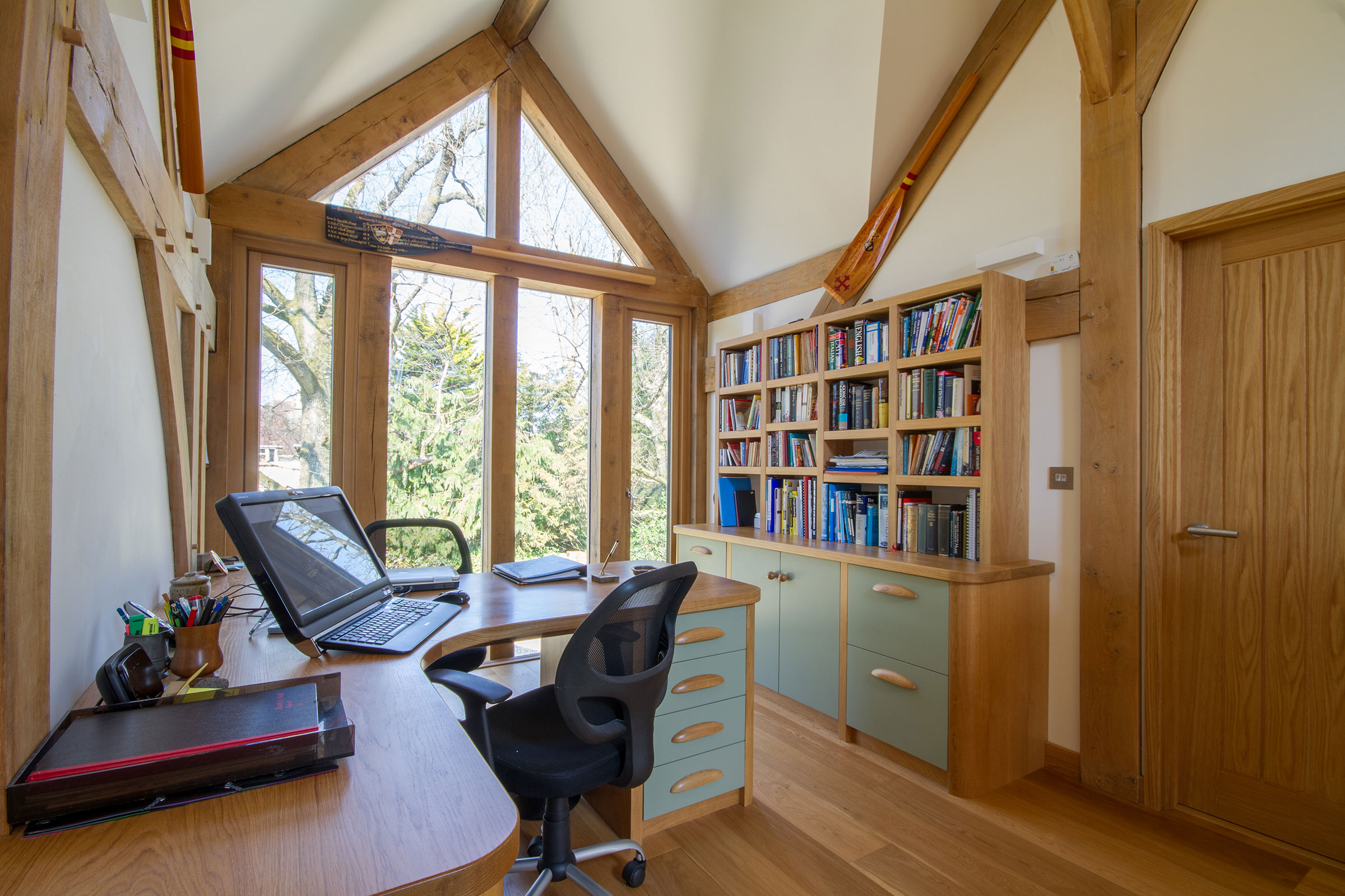 Fitted office furniture in wood stained to match existing beams