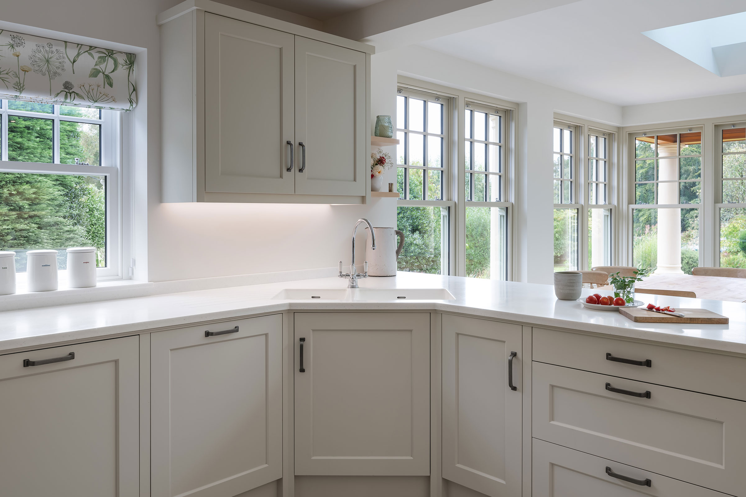 a light and bright skaker style kitchen with corian worktops